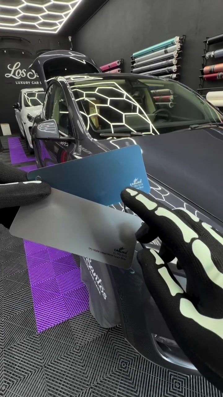 A physical material sample held beside a Tesla