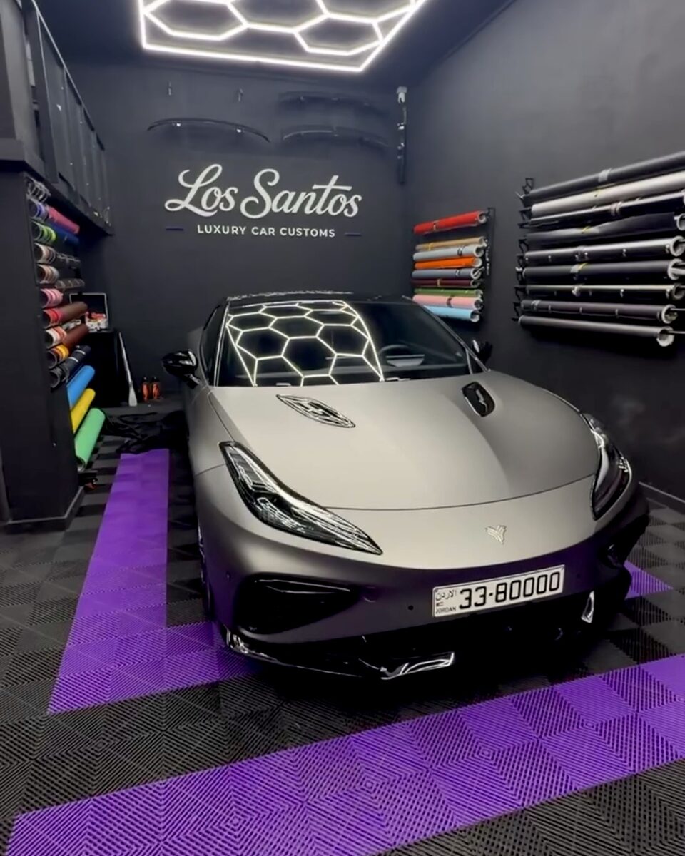 Front view of a Neta GT with a super matte grey color wrap inside the Los Santos studio